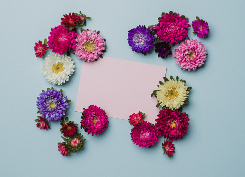 Creative flower arrangement frame with paper note. Place for text.