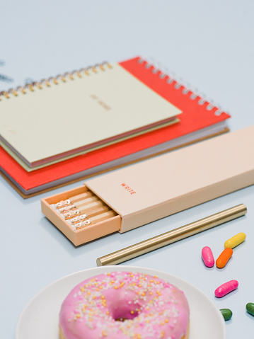 Stationery from above with notebook pencils and donut
