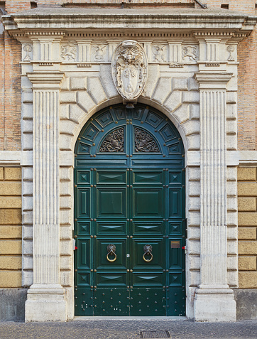 Old green door with arch of  palazzo Cesi 16th century. Rome, Italy