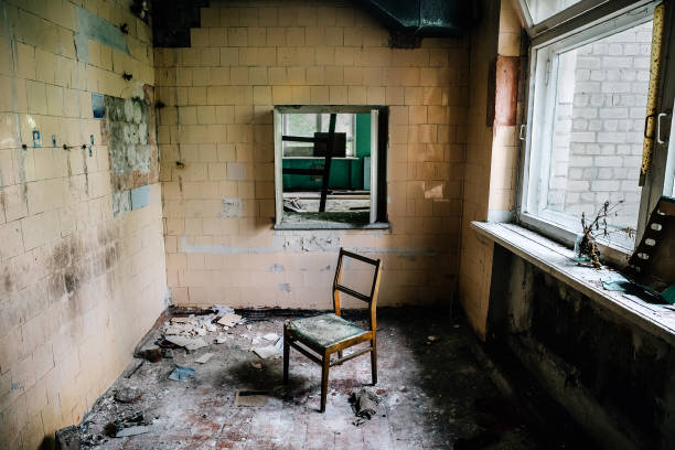 Room inside an old abandoned building, chair in the middle of the ruined room