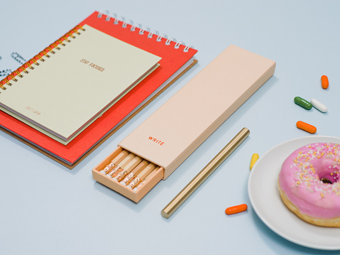 Stationery from above with notebook pencils and donut