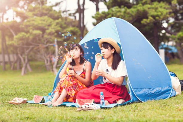 istock Two Women Enjoying Blowing Bubbles In Summer 835415434