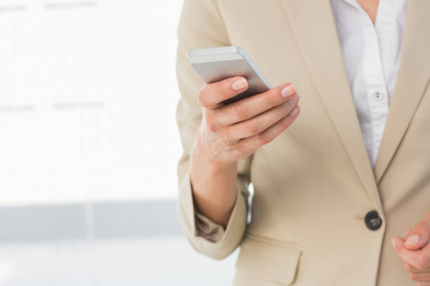 istock Mid section of a businesswoman text messaging 835418614
