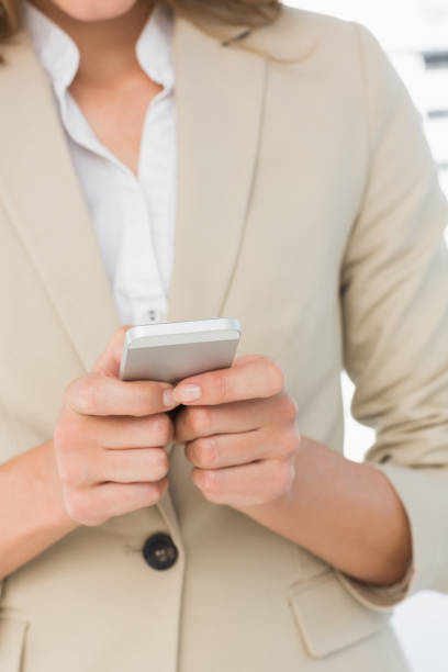 istock Mid section of a businesswoman text messaging 835421438
