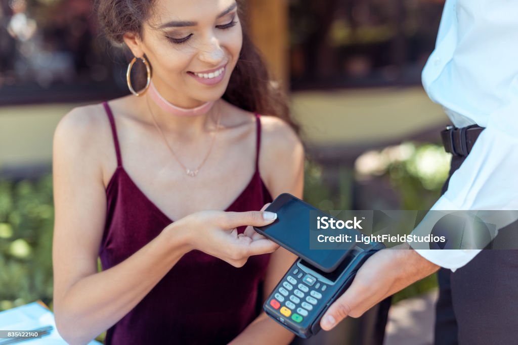 woman paying with NFC technology Close-up view woman paying with NFC technology on smartphone Checkout Stock Photo