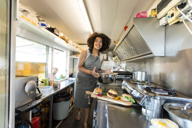 istock Smiling female food van worker making sandiches 835428934