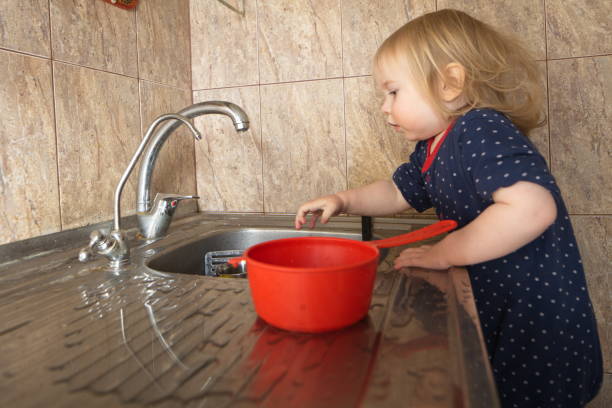 istock Blond baby washes dishes at home 835429920