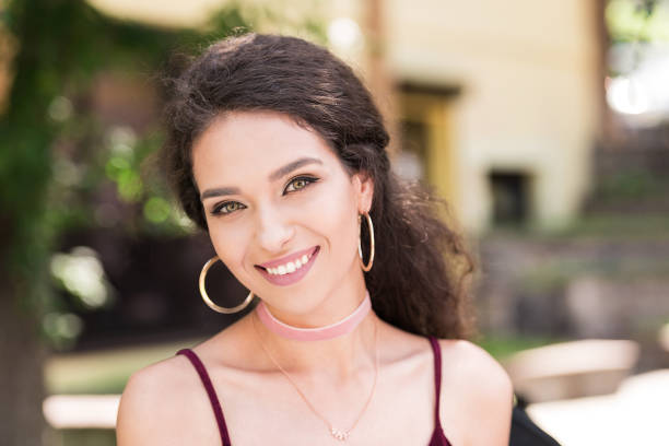 Fresh faced young woman with long brown hair smiling