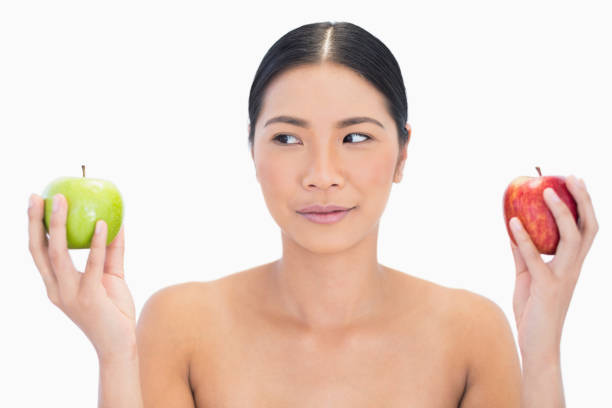 schwarzen haaren modell hält äpfel in beiden händen blick auf grün - sensuality women apple naked stock-fotos und bilder