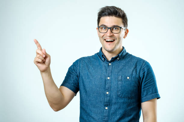 istock Handsome smiling bearded man pointing away on gray background 835444400