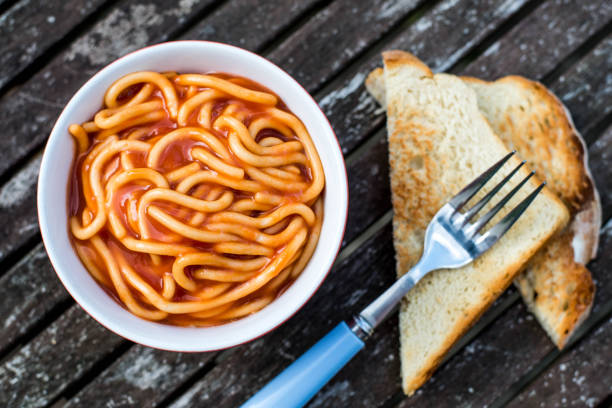 Bowl of Spaghetti in Tomato Sauce Against a Dark Weathered Table Top