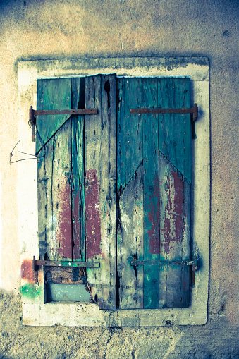 Old delapidated, grunge painted window shutter in the town of Kotor in Montenegro