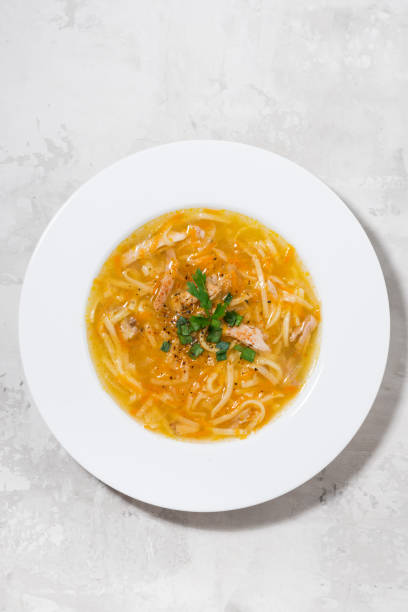 istock chicken soup with egg noodles, vertical top view 835471228