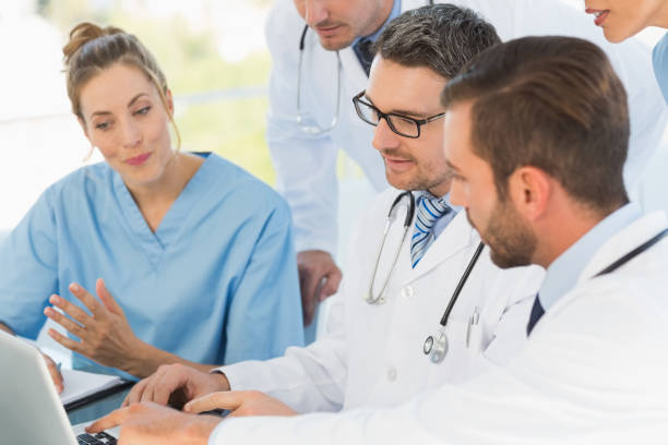 istock Group of concentrated doctors using laptop together 835493878
