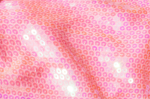 The texture of fabric lace with sequins on fabric background. Magenta, Hot pink, Cerise