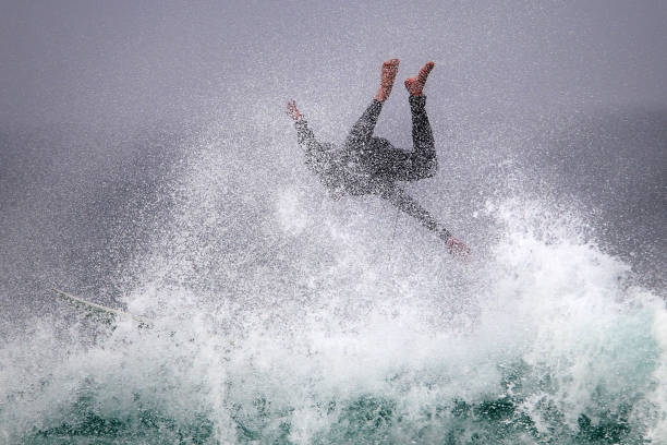 a surfer wipes out on a big wave. - big wave surfing imagens e fotografias de stock