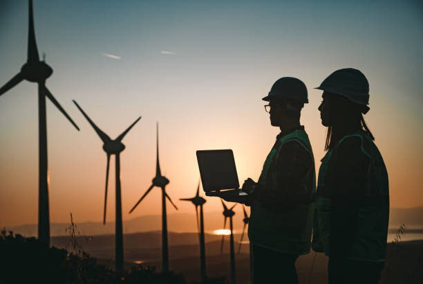 istock Young maintenance engineer team working in wind turbine farm at sunset 835501802