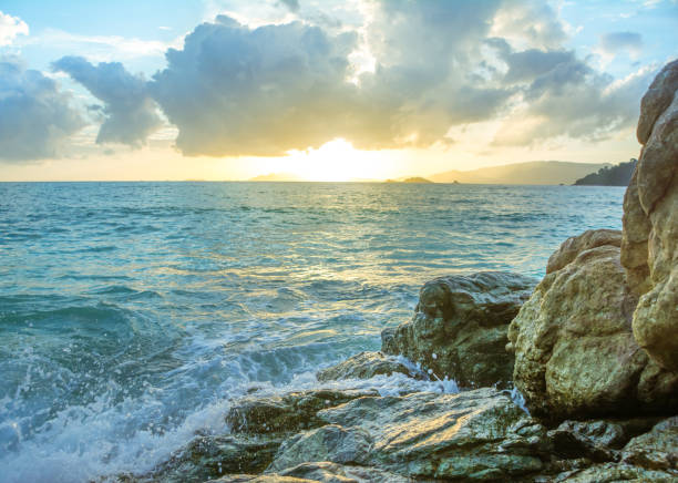 istock Splash waves hit rocks with the beautiful sunset and sky . 835508122