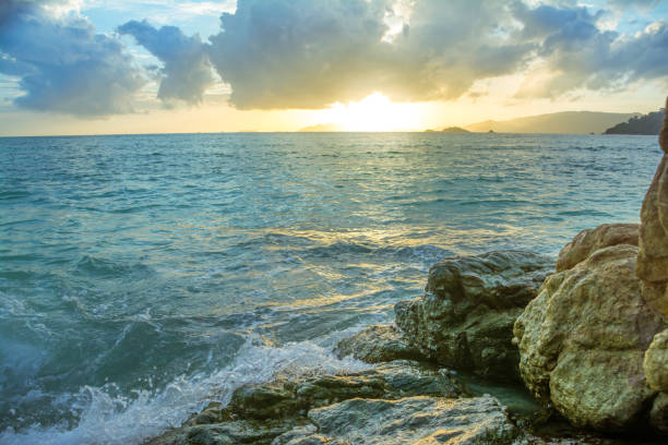 istock Splash waves hit rocks with the beautiful sunset and sky . 835508858