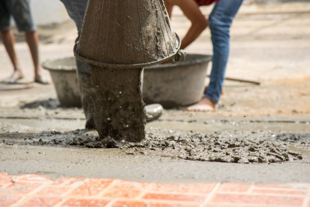 istock labor pouring cement on the ground for build new floor 835519820