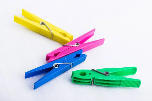 Four colorful clothespins on a white surface.