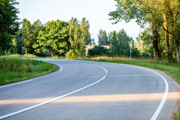 istock country road with sun rays in the morning 835545926
