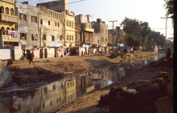 Backstreets along a canal in the old city section of Lahore Pakistan Backstreets along a canal in the old city section of Lahore Pakistan lahore pakistan photos stock pictures, royalty-free photos & images