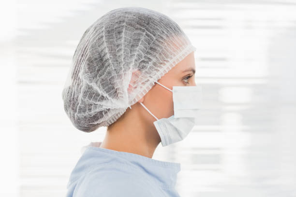 Closeup side view of a female surgeon wearing surgical cap and mask in the hospital