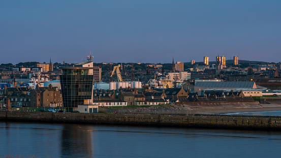 Aberdeen harbour, Scotland, United Kingdom, 16th August 2017. Aberdeen harbour and city at dawn with the Marine Operations Tower on the sea wall.