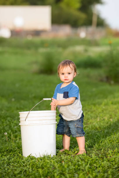 istock One Year Old Boy With White Pail on Farm 835584610