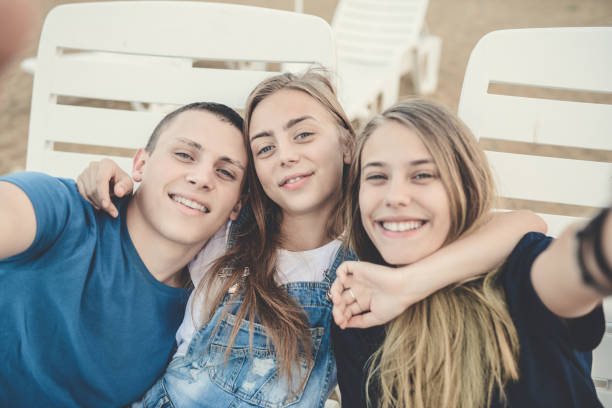 istock Embraced Smiling Friends Taking Crazy Selfie at the Beach 835596872