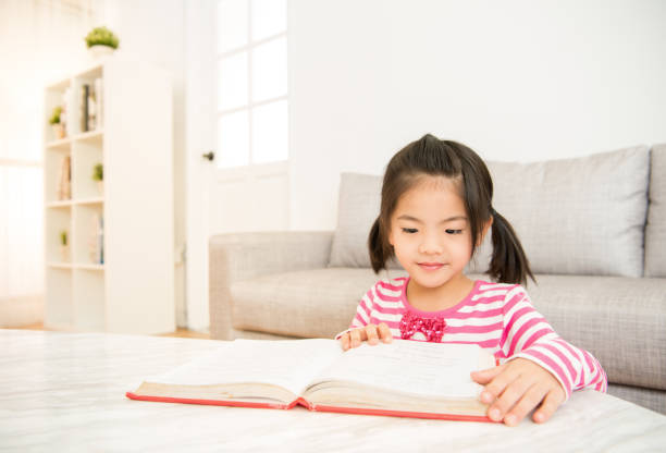 istock clever girl at table with reading books 835617408