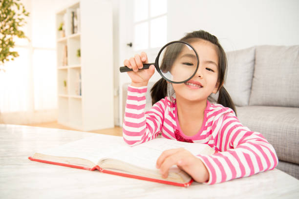 istock Student girl reading with magnifying glass 835618374