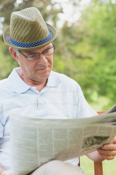 istock Senior man reading newspaper at park 835626836