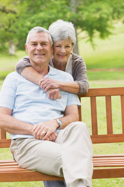 istock Senior woman embracing man from behind at park 835627342