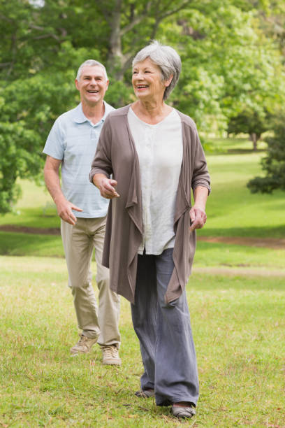 istock Happy senior couple walking in park 835628652