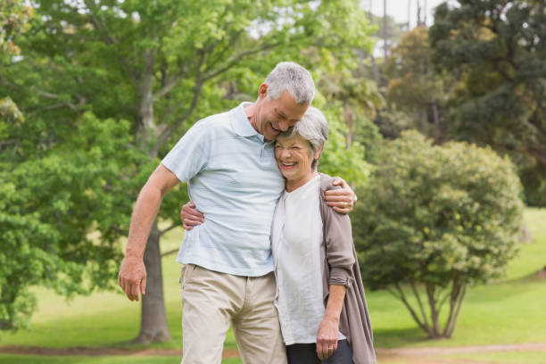 istock Happy senior couple embracing in park 835629210