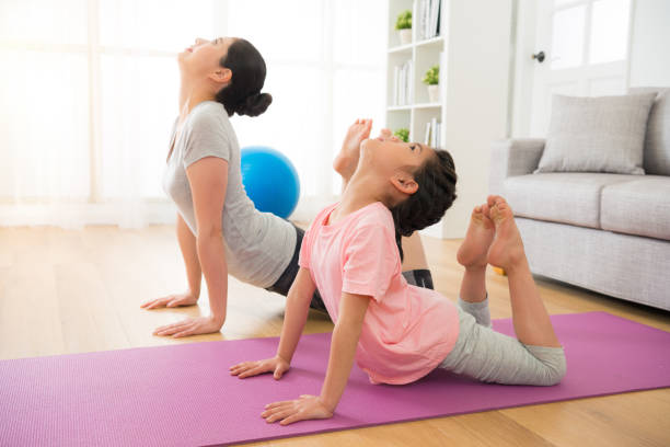 istock mother and daughter doing yoga exercises 835640114