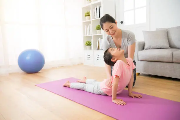 mother teaching her small girl his yoga notions