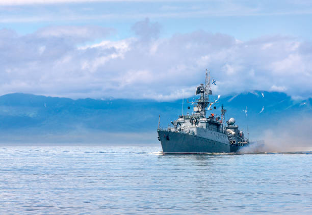 Russian warship going along the coast Russian warship going along the coast of Kamchatka frigate stock pictures, royalty-free photos & images