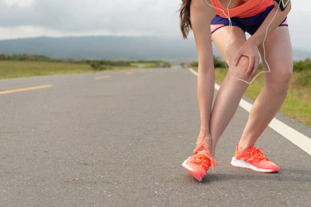 istock female athlete ankle injury when running on road 835671742
