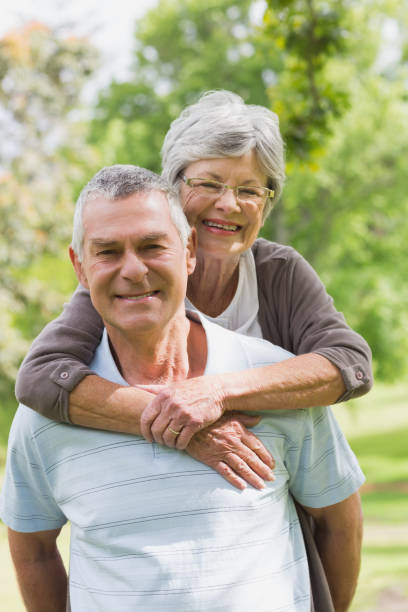 istock Senior woman embracing man from behind at park 835700926