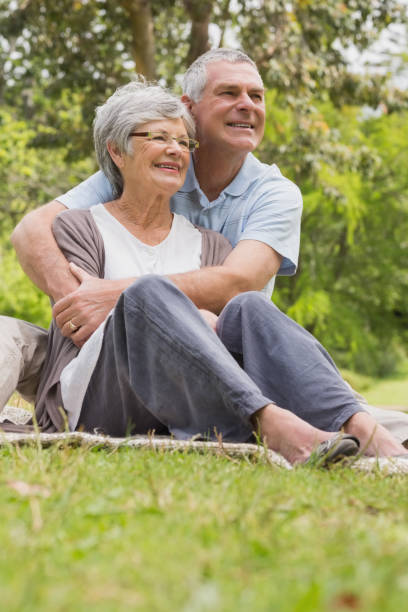 istock Senior man embracing woman from behind at park 835703102