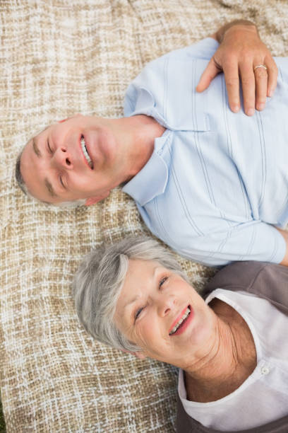 sourire détendu couple de personnes âgées se trouvant dans le parc - couple affectionate relaxation high angle view photos et images de collection