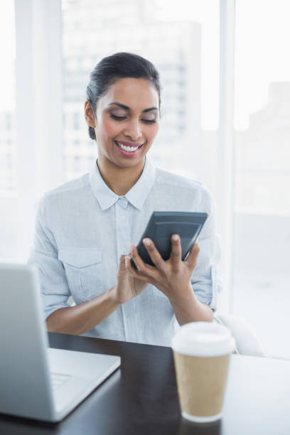 istock Content businesswoman using a calculator sitting at her desk 835703624