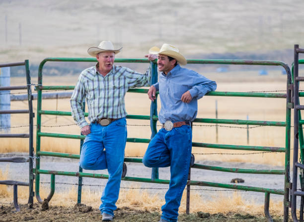 istock Two Cowboys Stand Talking At A Fence 835710530