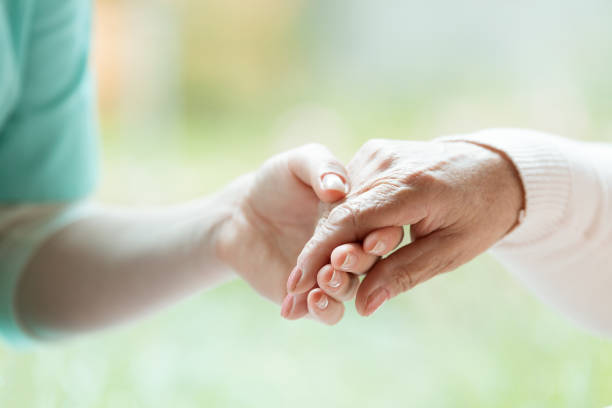 Hand of nurse Hand of nurse holding elder woman's in sweater palm nurse smock stock pictures, royalty-free photos & images