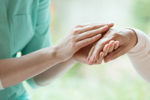 istock Caretaker massaging pensioner's hand 835733154