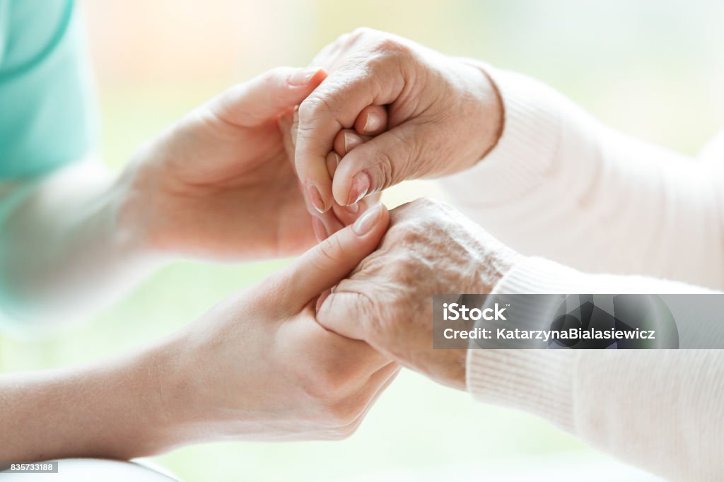 Close-up of holding hands Photo with close-up of caregiver and patient holding hands Parkinson's Disease Stock Photo