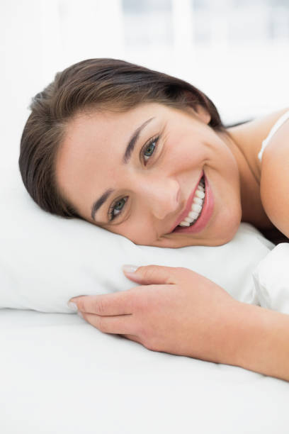 istock Smiling young woman resting in bed 835733366